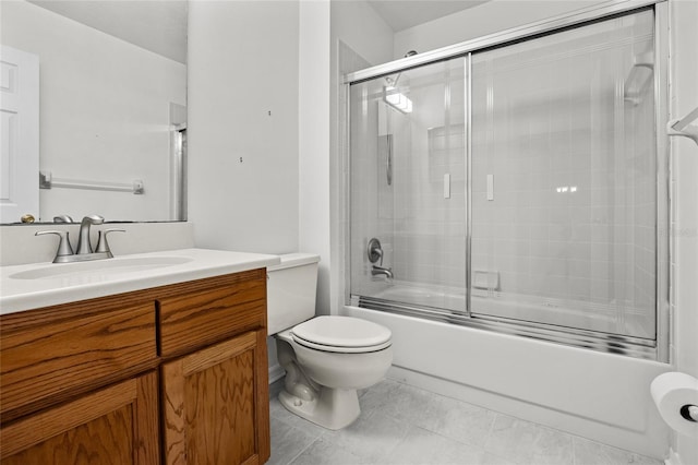 full bathroom featuring combined bath / shower with glass door, tile patterned floors, vanity, and toilet