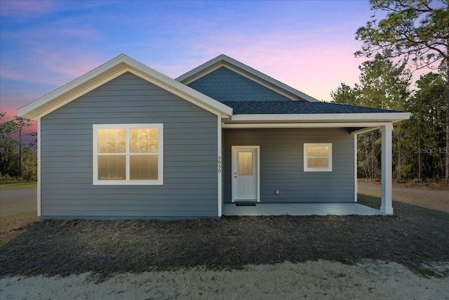 rear view of property with roof with shingles