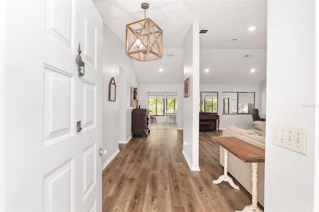 foyer featuring a chandelier, hardwood / wood-style floors, and vaulted ceiling