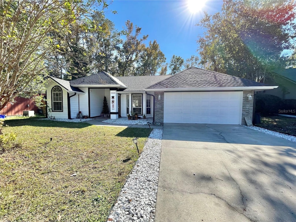 single story home with a front yard and a garage