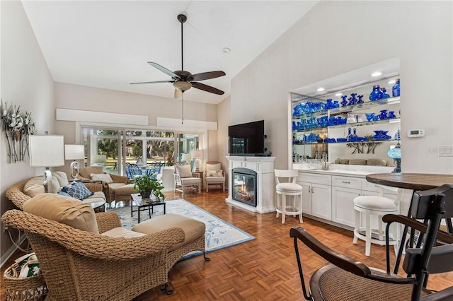 living room featuring ceiling fan, dark parquet floors, and high vaulted ceiling