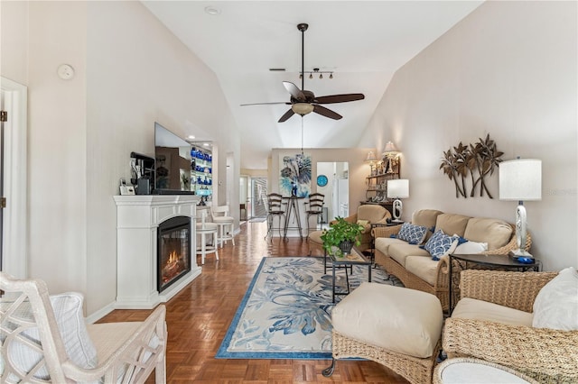 living room with dark parquet flooring, vaulted ceiling, and ceiling fan