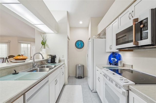 kitchen with white cabinetry, white appliances, sink, and light tile patterned floors