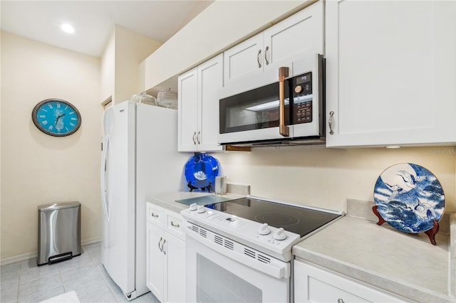 kitchen featuring white cabinetry, light tile patterned flooring, and white appliances