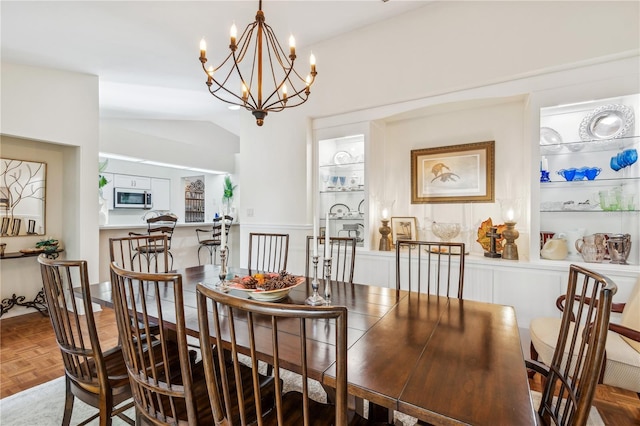 dining space with parquet flooring and an inviting chandelier