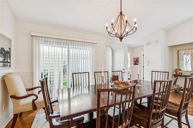 dining area featuring a notable chandelier and parquet floors