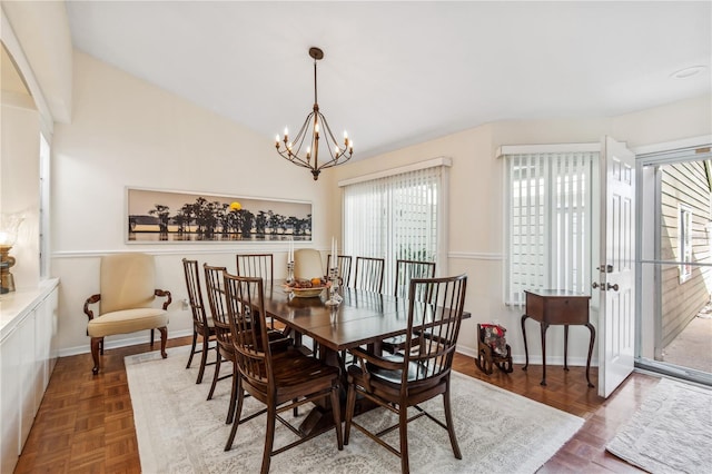 dining area with a notable chandelier, parquet flooring, and vaulted ceiling