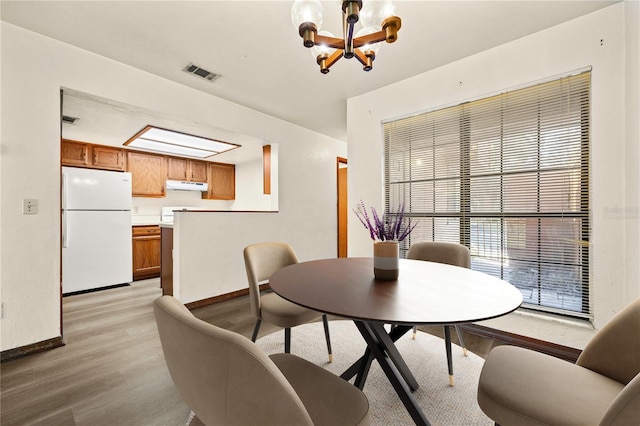 dining room featuring a chandelier and light hardwood / wood-style flooring