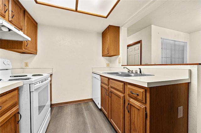 kitchen featuring kitchen peninsula, sink, dark hardwood / wood-style floors, and white appliances