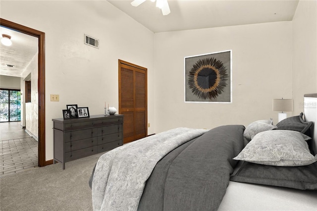 bedroom with ceiling fan, a closet, carpet, and vaulted ceiling