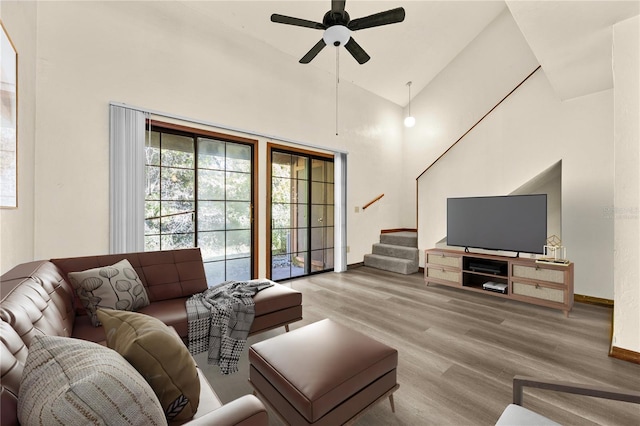 living room featuring ceiling fan, high vaulted ceiling, and wood-type flooring