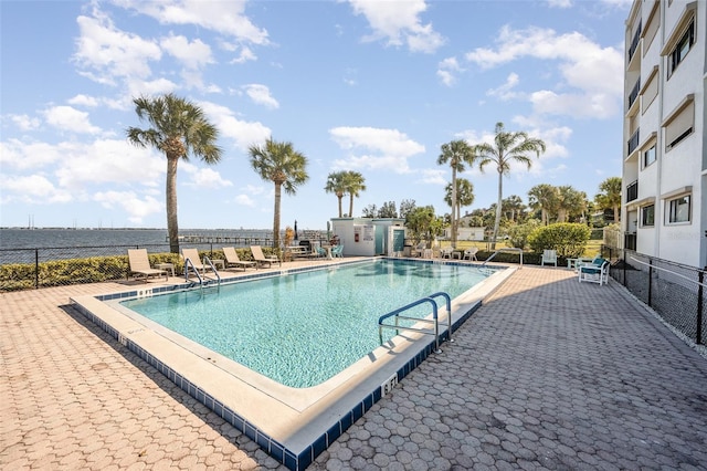 view of pool with a water view and a patio area