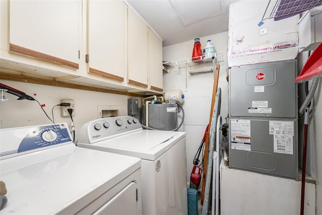 clothes washing area featuring washer and clothes dryer, cabinets, and heating unit