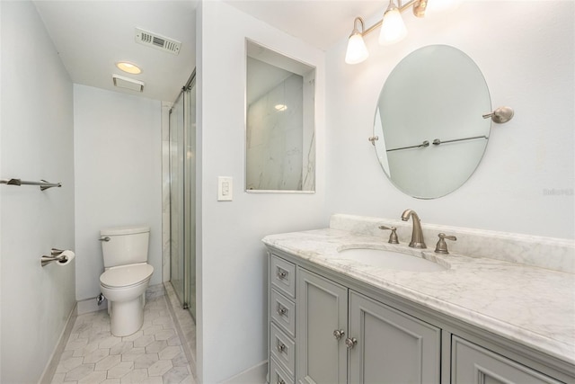 bathroom featuring tile patterned flooring, vanity, a shower with shower door, and toilet