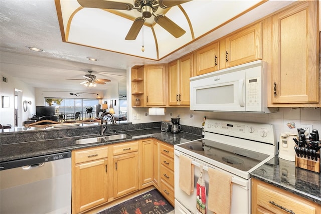 kitchen with sink, light brown cabinets, dark stone countertops, a textured ceiling, and white appliances