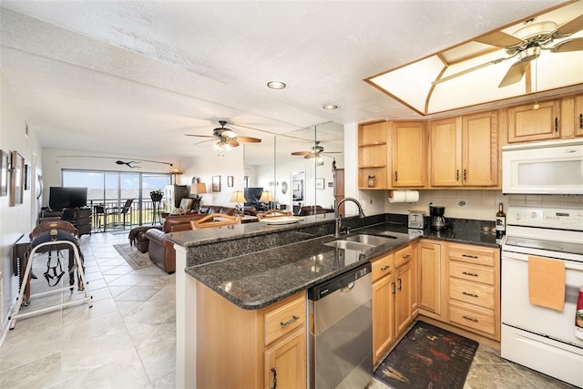 kitchen featuring kitchen peninsula, a textured ceiling, white appliances, sink, and dark stone countertops