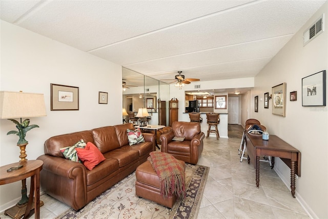 living room with a textured ceiling and ceiling fan