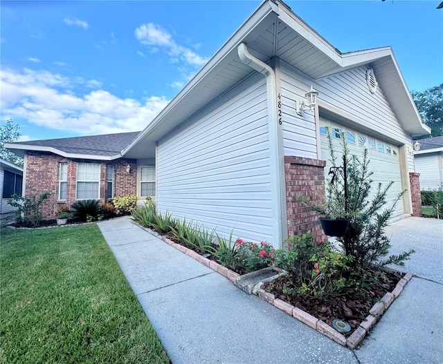 view of home's exterior with a yard and a garage