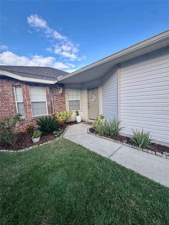 doorway to property featuring a lawn