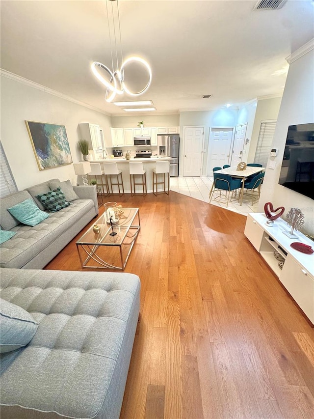 living room featuring ornamental molding and light hardwood / wood-style flooring