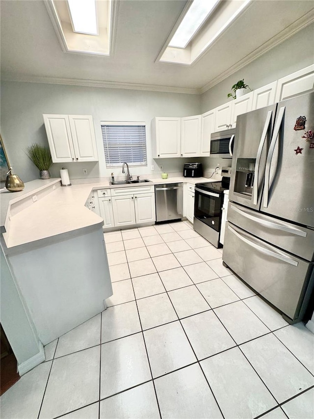 kitchen with a skylight, sink, stainless steel appliances, crown molding, and white cabinets