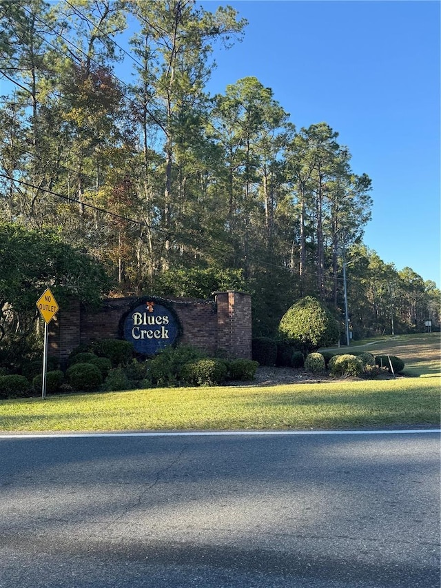 community / neighborhood sign with a yard