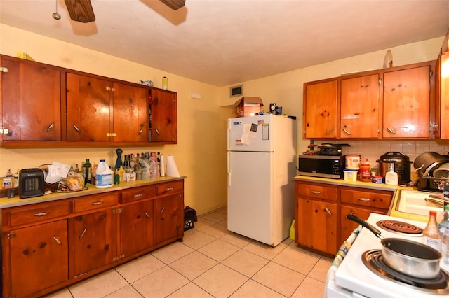 kitchen featuring tasteful backsplash, white appliances, ceiling fan, sink, and light tile patterned floors