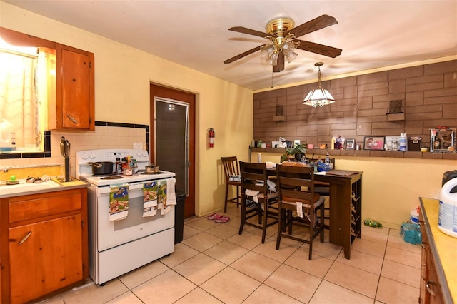 kitchen with decorative backsplash, white electric range oven, ceiling fan, light tile patterned floors, and hanging light fixtures