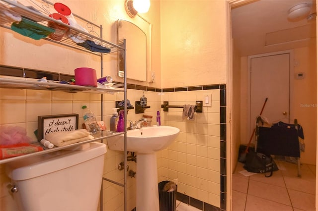 bathroom featuring tile patterned floors, tile walls, and toilet