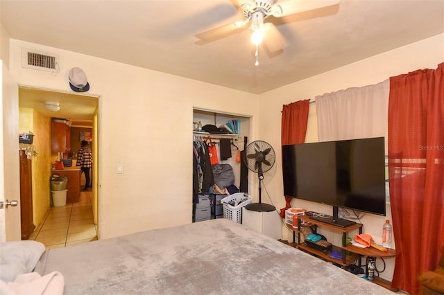 tiled bedroom featuring ceiling fan and a closet