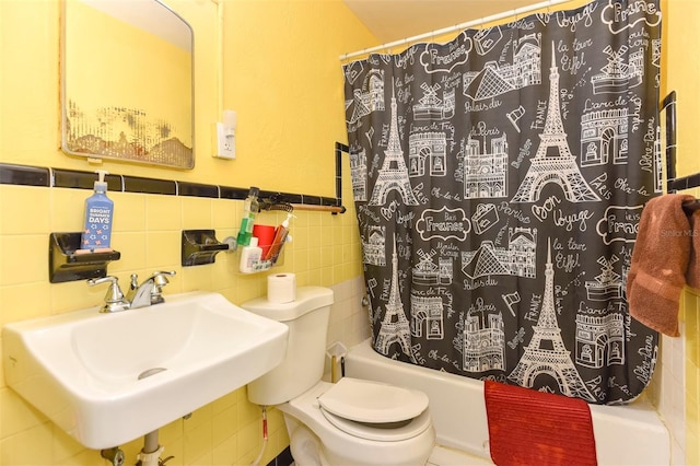 full bathroom with sink, shower / bath combo, tile walls, and toilet