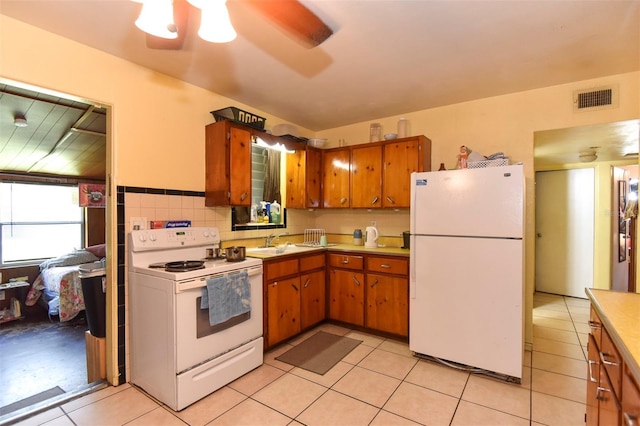 kitchen featuring ceiling fan, sink, white appliances, decorative backsplash, and light tile patterned flooring