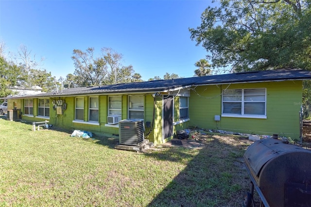 ranch-style home with cooling unit and a front yard