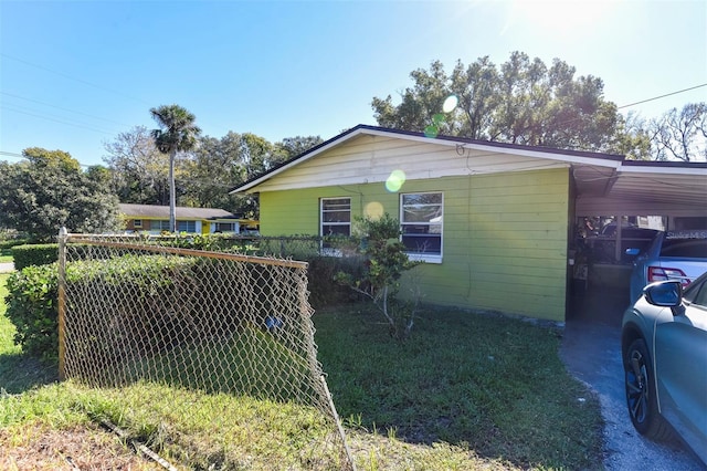 view of property exterior featuring a carport and a lawn