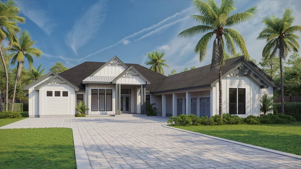 view of front of home featuring decorative driveway, roof with shingles, an attached garage, board and batten siding, and a front yard