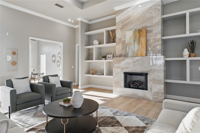 5040 SW 125th Cir, Archer, FL 32618 - living room with wood finished floors, built in shelves, a tile fireplace, and crown molding
