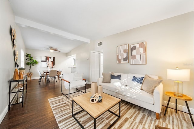 living room featuring lofted ceiling with beams, ceiling fan, and dark wood-type flooring