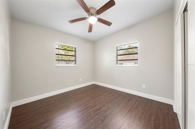 spare room featuring dark hardwood / wood-style flooring, a wealth of natural light, lofted ceiling, and ceiling fan