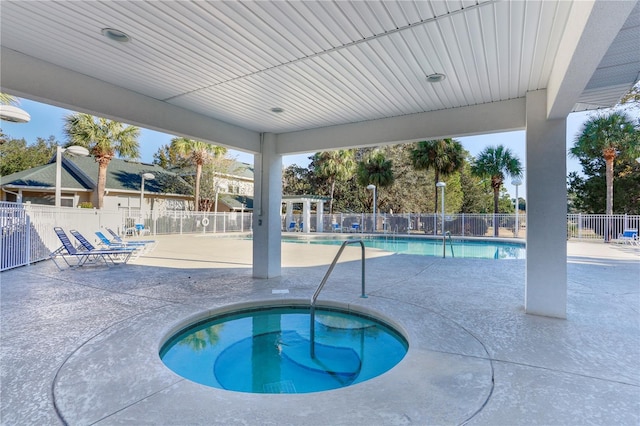 view of swimming pool featuring a patio area and a hot tub