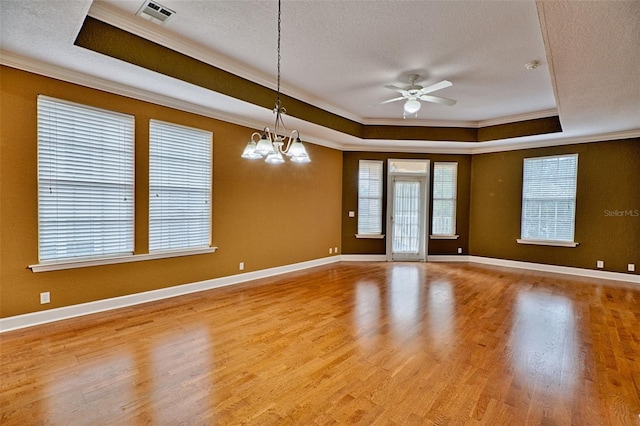 spare room featuring ornamental molding, a tray ceiling, and light hardwood / wood-style floors