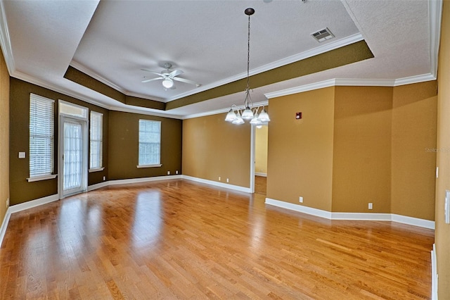 unfurnished room with crown molding, a raised ceiling, ceiling fan with notable chandelier, and light hardwood / wood-style flooring