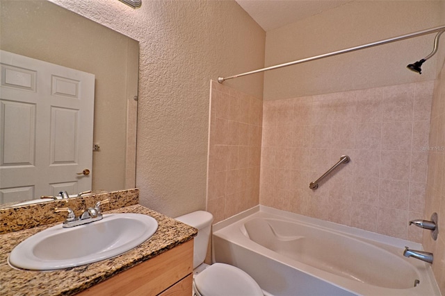 full bathroom with vanity, tiled shower / bath, and toilet