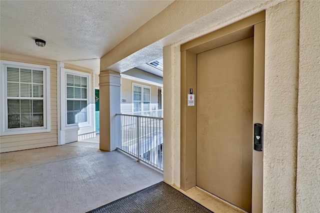 entrance to property with elevator and a balcony