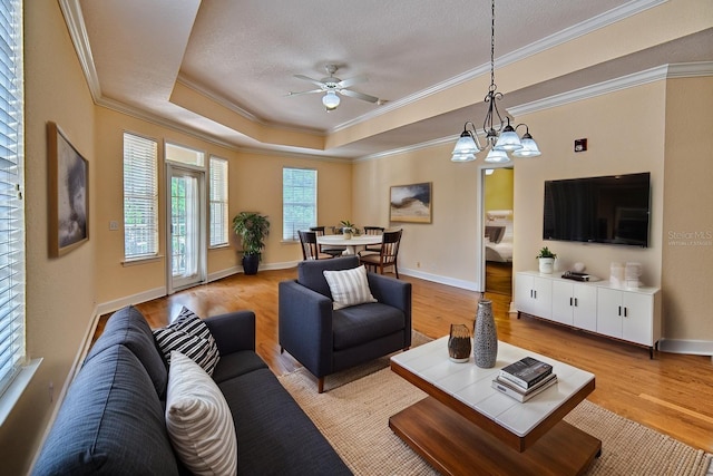4715 SW 91st Dr Unit 305, Gainesville, FL 32608 - living room featuring crown molding, light wood-type flooring, a tray ceiling, a ceiling fan, and a chandelier