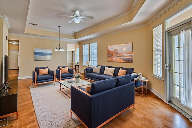 4715 SW 91st Dr Unit 305, Gainesville, FL 32608 - living room with a tray ceiling, ornamental molding, light wood-type flooring, a ceiling fan, and a chandelier