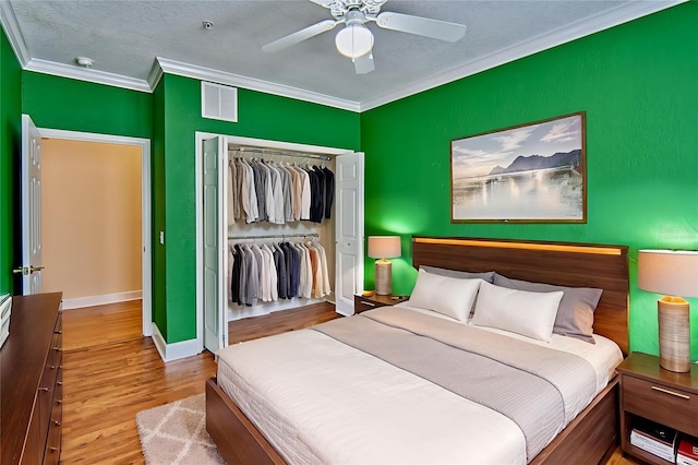 4715 SW 91st Dr Unit 305, Gainesville, FL 32608 - bedroom with ornamental molding, a closet, wood finished floors, ceiling fan, and a textured ceiling