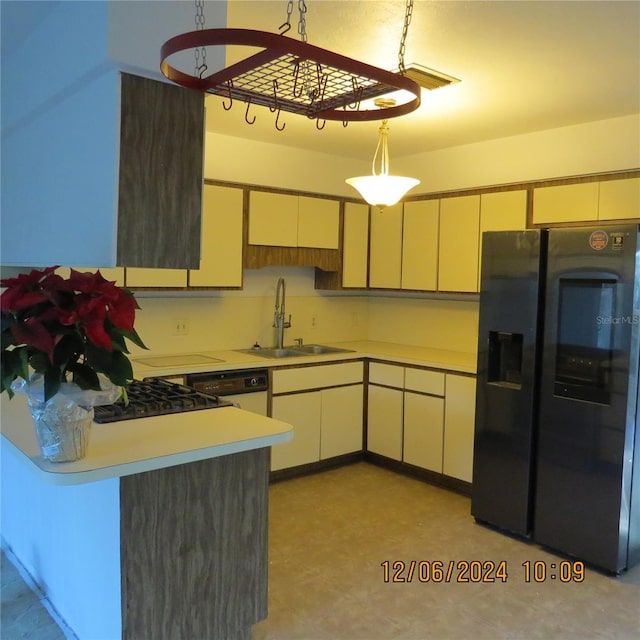 kitchen featuring pendant lighting, dishwasher, sink, and black refrigerator with ice dispenser