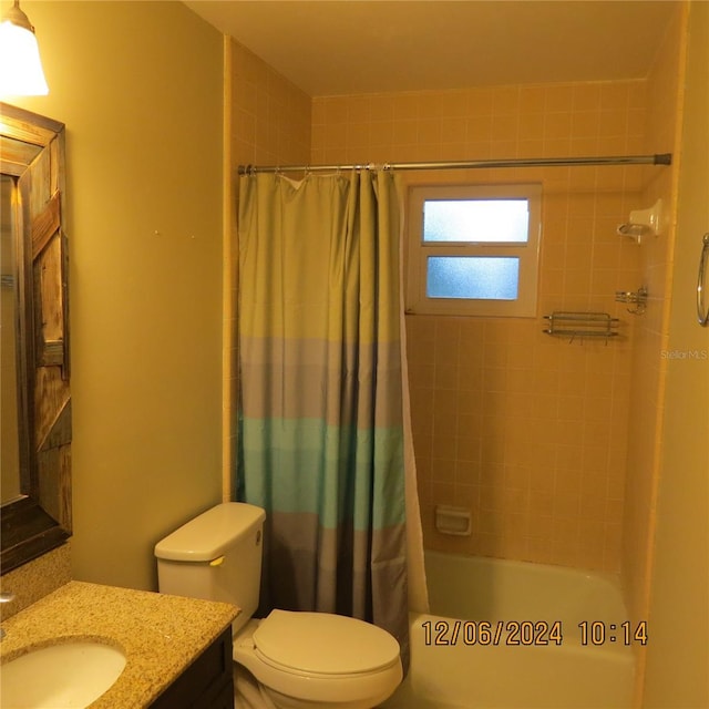 full bathroom featuring shower / bath combination with curtain, vanity, and toilet