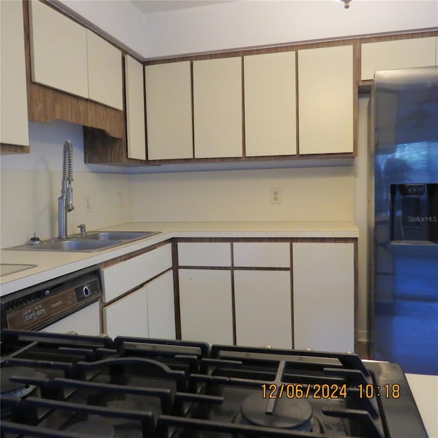 kitchen featuring white cabinetry, sink, white dishwasher, and stainless steel refrigerator with ice dispenser