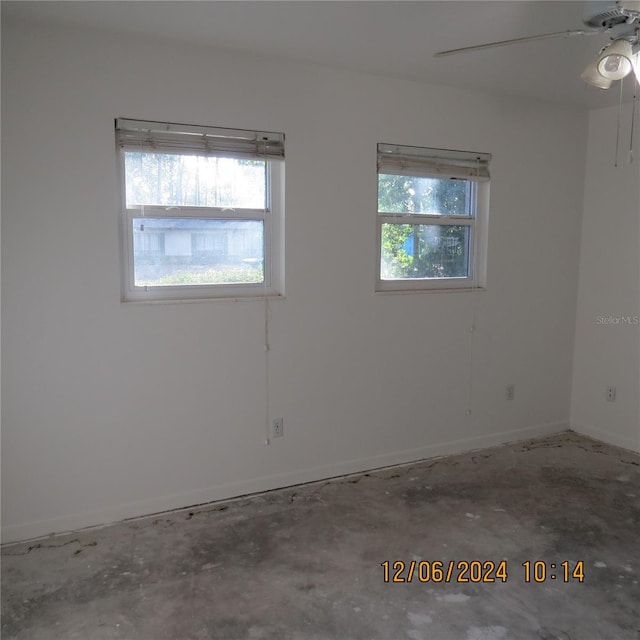 unfurnished room featuring ceiling fan and concrete flooring